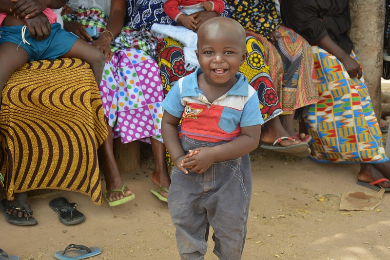 A toddler in The Gambia grins for the camera.