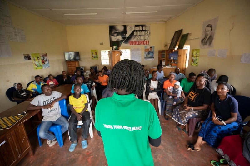 A peer educator talks to a group of people in Zambia.