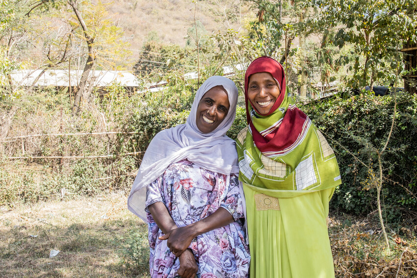 Two women in Ethiopia smile at the camera.