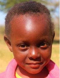 A 4-year-old girl in Zambia smiles at the camera.